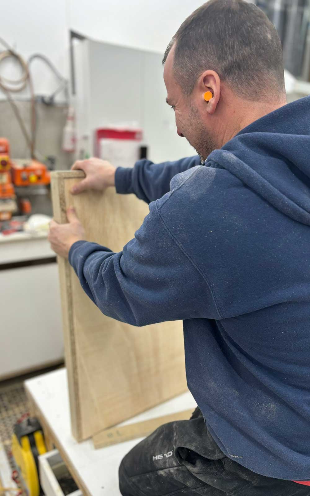 Homme mesurant une planche en bois
